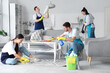 © Pixel-Shot - Team of young janitors cleaning in room