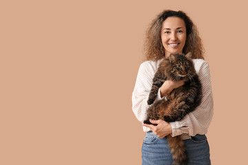 Wall Mural - Beautiful mature woman with cute cat on brown background