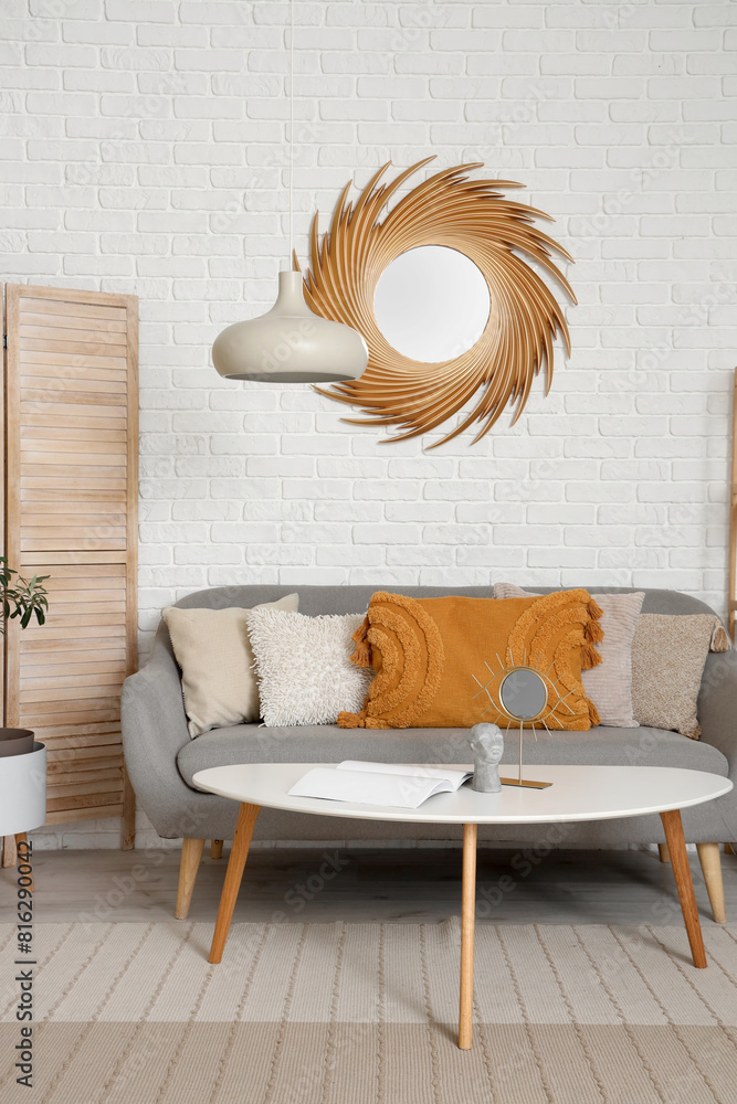 Interior of living room with golden mirror, table and sofa
