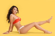 © Pixel-Shot - Beautiful young woman in swimsuit on yellow background