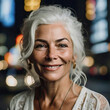 stupendo ritratto di donna di mezza età con capelli bianchi raccolti viso sorridente con rughe di espressione naturale su sfondo sfuocato urbano in città notturna