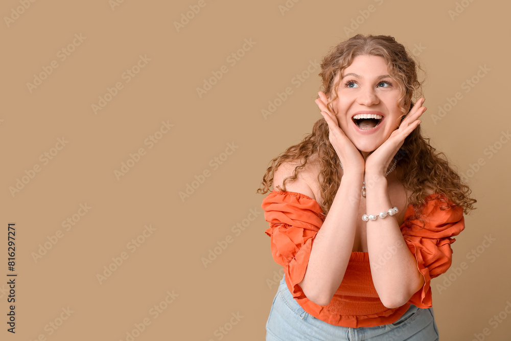 Happy beautiful young woman on brown background