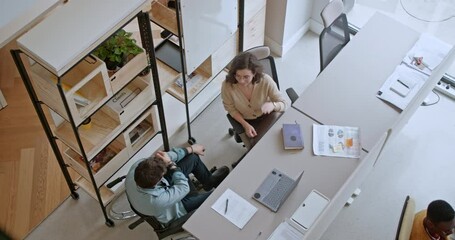 Canvas Print - Top view inclusive teammates collaborate and brainstorm solutions for a business startup project in a well-lit workspace, showcasing their diverse perspectives and teamwork in driving innovation.