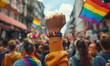 © zeenika - People's raised fist with rainbow flag during pride parade