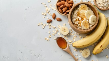 Sticker - Ingredients for preparing oatmeal in a wooden bowl with almonds banana slices honey oat flakes and a spoon on a white surface Top view with space for text