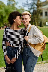 Wall Mural - A pair of young women, stylish in casual attire, striking a pose together in a picturesque park