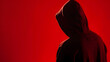 © Generative AI - Silhouette af man without face in hood on a red background Anonymous crime concept : Generative AI