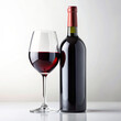 A chic arrangement featuring a sophisticated bottle of red wine and a modern wine glass, set against a pristine white background, suitable for advertising purposes.