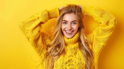 Wall Mural -  A beautiful woman, clad in a yellow sweater, smiles and poses for the camera with her hands framing her head