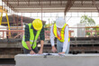 © JU.STOCKER - Engineer and foreman worker team checking project at precast concrete factory site, Engineer and builders in hardhats discussing on construction site