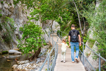 Wall Mural - Father with little girl hiking in Sapadere canyon with wooden paths and cascades of waterfalls in the Taurus mountains, Turkey. Eco tourism concept