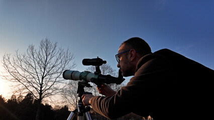 Wall Mural - amateur astronomer observing sun eclipse and sun with a telescope and special solar filter.