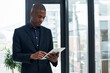 © peopleimages.com - Online, lawyer and black man with tablet in office for legal research, app or advisor planning. Reading, news or professional attorney typing business email, networking or reminder to chat to contact