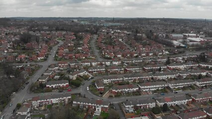 Wall Mural - Aerial drone Footage above a typical housing estate in the UK, showing businesses, rows of houses and roads with traffic on a cold winters day, taken in Kirkstall in Leeds West Yorkshire UK