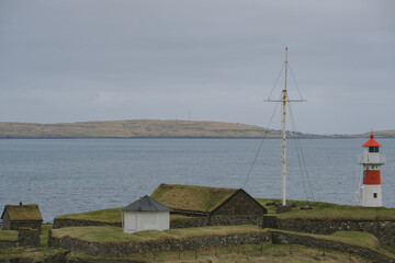 Wall Mural - Rough but beautiful Faroer Island coast line nature landscape panoramic scenery near Torshavn with traditional houses and farms, archipelago islands cloudy day