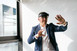 © Koldo_Studio - A businessman in a suit interacts with a VR headset, experiencing augmented reality in a professional workspace.