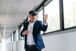 © Koldo_Studio - A businessman in a suit uses a VR headset in an office hallway, demonstrating augmented reality technology.