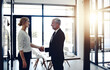 © peopleimages.com - Business people, smile and agreement with handshake in office for partnership, opportunity and success. Corporate, director and hand with gesture in deal for b2b merger, collaboration and acquisition