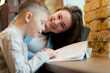 © Guys Who Shoot - close up in bookstore near the window a young mother sits teaching her son to read child development