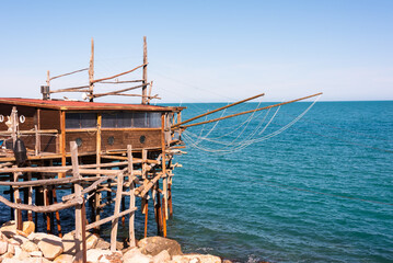 Wall Mural - Traditional wooden fishing house with a net near sea coast