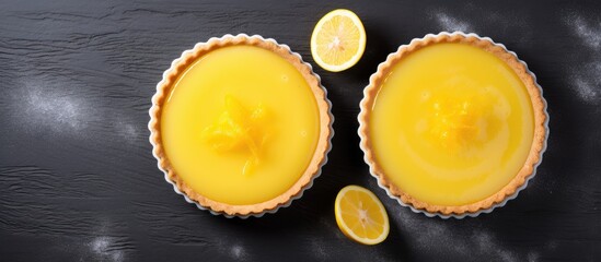 Wall Mural - top view of two beautifully decorated lemon curd tarts with plenty of copy space image