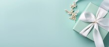 Copy Space Image Of A Top View Flat Lay Featuring A White Gift Box Adorned With A Tiffany Satin Ribbon Against A Serene Mint Blue Backdrop