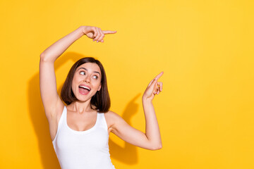 Wall Mural - Photo portrait of attractive young girl point look empty space wear trendy white outfit isolated on yellow color background