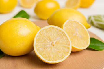 Wall Mural - Top view with copy space for fresh and ripe lemons on cutting board. Healthy food background. Elegant background of lemon and lemon slices with squeezer colored background