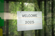 © sinseeho - Welcome 2025 on a signboard, hanging on a glass door.