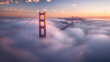 © Santy Hong - The sun rises behind the fog-covered Golden Gate Bridge, casting a warm, golden glow over the misty landscape as the city awakens to a new day.
