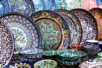 Wall Mural - Vibrant display of handcrafted Samarkand ceramics, richly designed plates and bowls in bold colors and intricate patterns. Traditional Uzbek souvenir. Samarkand, Uzbekistan