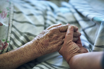 Wall Mural - Senior person, hands and visit with hospital, closeup and pensioner care or love together. Elderly people, couple and relationship for medical checkup, help or empathy for surgery recovery and health