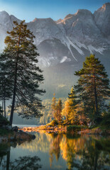 Wall Mural - Idyllic scenery at German lake Eibsee in the Alps, with mountains and trees reflected in the clear water and beautiful light