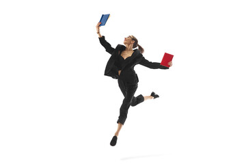 Businesswoman in mid-air pose, reading book in a jump, showcasing corporate success and continuous learning, isolated on white background. Concept of business, office lifestyle, professional growth