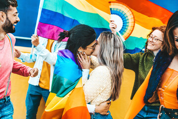 Wall Mural - LGBTQ people celebrating gay pride festival together - Diverse friends holding rainbow flag