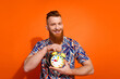 © deagreez - Photo of positive good mood guy dressed print shirt showing clock isolated orange color background