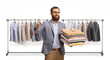 © Ljupco Smokovski - Man gesturing thumbs up in front of a rack with hanging clothes