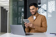 © Tetiana - Young professional man using digital tablet at work in modern office setting