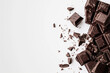 © Emanuel - Artfully arranged dark chocolate pieces on a white background, showcasing indulgence
