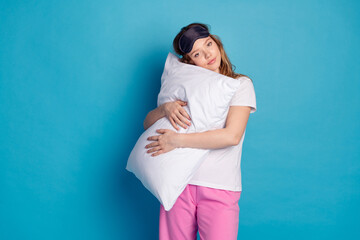 Sticker - Photo of sweet lovely cute girl wear white stylish pajama hands hold soft pillow isolated on blue color background