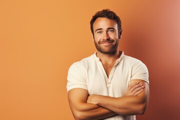 Wall Mural - Portrait of a satisfied man in his 30s with arms crossed while standing against pastel or soft colors background