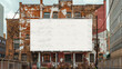 © Natalia - A large blank billboard mounted on the side of an old, weathered brick building with a faded mural. Nearby buildings and fencing surround the urban scene.