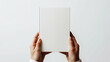 © Natalia - Minimalist mockup image featuring hands holding a blank white book against a light background, ideal for showcasing book cover designs or branding concepts.
