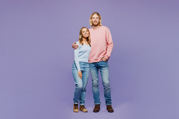 Wall Mural - Full body smiling happy young satisfied couple two friends family man woman in pink blue casual clothes together looking camera isolated on pastel plain light purple color background studio portrait