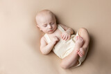 Fototapeta Do akwarium - a small child lies on a light background. newborn boy. baby's first photo shoot