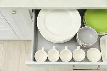 Poster - Clean plates, bowls and cups in drawer indoors, top view