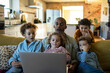 © Marko Geber - Happy diverse family enjoying time together with laptop at home