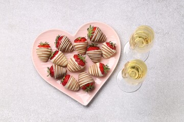 Wall Mural - Heart shaped plate with delicious chocolate covered strawberries and sparkling wine on light table, flat lay