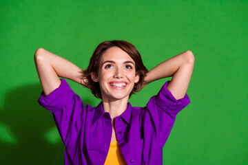 Poster - Portrait of young sleepy pleasure woman in purple shirt take nap looking above relaxed dreaming isolated on green color background