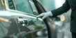 © Anastasiia - Professional chauffeur opens limousine door providing luxury chauffeur service near car. Concept Luxury Car Service, Professional Chauffeur, Limousine Transportation, High-End Client Experience